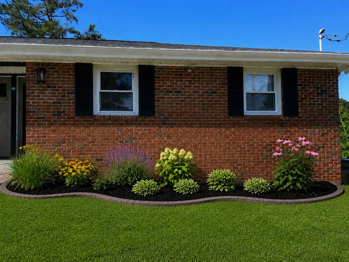 Clean curved edge around a flower bed in front of a brick house